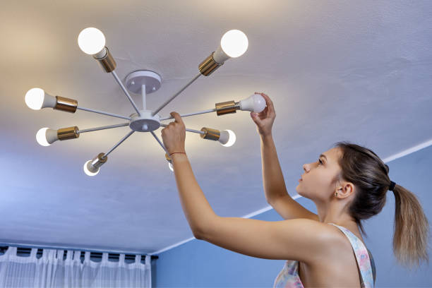istock Home light bulb replacement by woman in bedroom. 1350318922