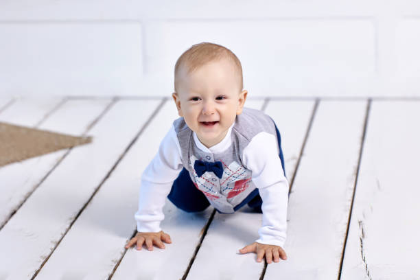 istock Cheerful white toddler crawls on floor in lounge. 1350318932