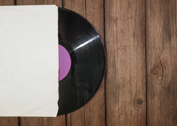 istock Old vinyl record in paper case on wooden rustic background 1350320696