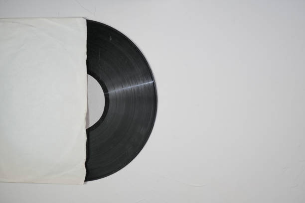 istock Old vinyl record in paper case on white marble background 1350320705
