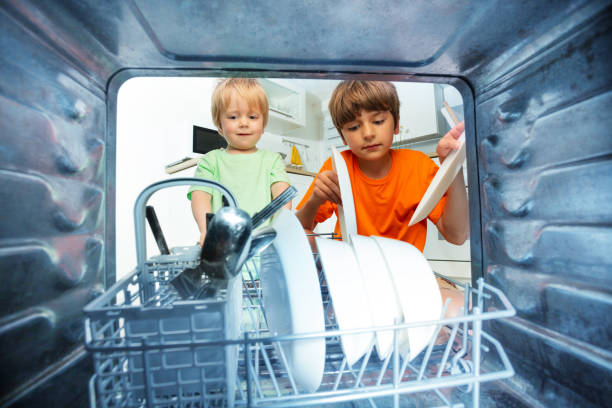 istock Two boys together take dishes form the dishwasher 1350321302