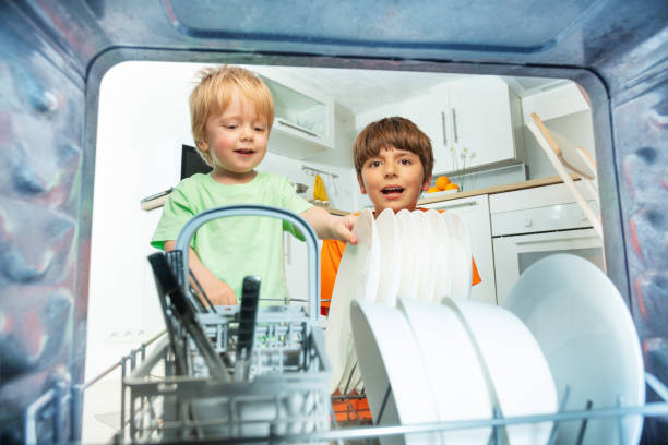 istock Two boys take dishes from dishwasher at kitchen 1350321305