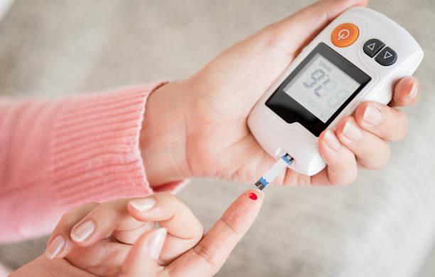 Close up woman hands checking blood sugar level by glucose meter for diabetes tester using as medicine, glycemia, healthcare and medical concept. Close up woman hands checking blood sugar level by glucose meter for diabetes tester using as medicine, glycemia, healthcare and medical concept. blood sugar CONTROL stock pictures, royalty-free photos & images