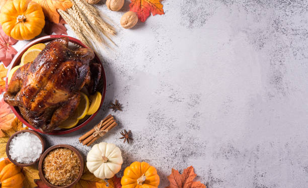 istock Thanksgiving dinner background concept with turkey roasted and all sides dishes, fall leaves, pumpkin and seasonal autumnal decor on stone background, top view, copy space. 1350334429