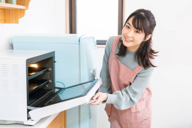 istock attractive asian woman cooks in a kitchen,oven, 1350336539
