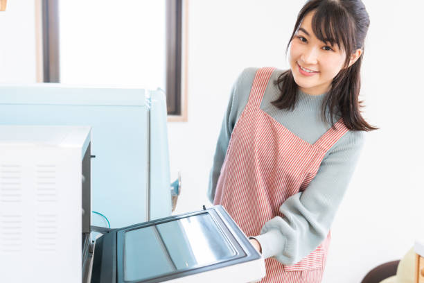 istock attractive asian woman cooks in a kitchen,oven, 1350336561