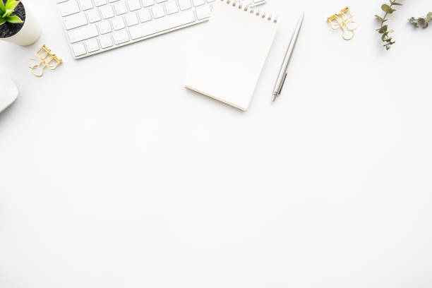 istock Small blank notebook with pen are on top of computer keyboard over white office desk table with office supplies. Top view with copy space, flat lay. 1350343426