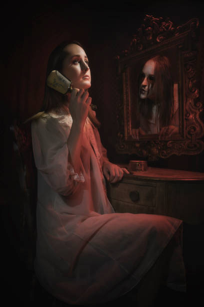 ビクトリア朝のシーンで若い女性は幽霊の虚栄心で髪を磨く - mirror women reflection ghost ストックフォトと画像