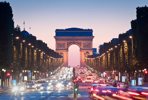 Pretty night time illuminations of the Impressive Arc de Triomphe (1833) along the famous tree lined Avenue des Champs-Elysees in Paris. ProPhoto profile for precise color reproduction.