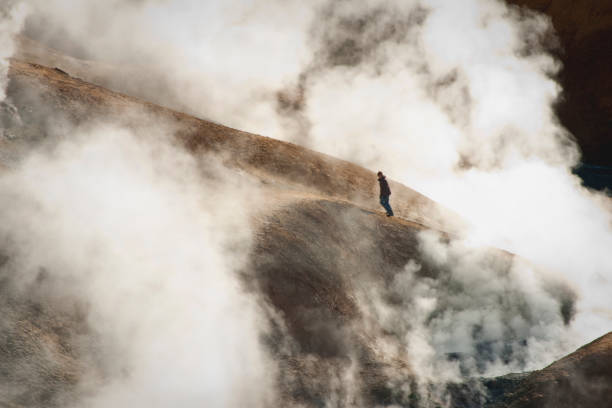 Kjolur Interior, Iceland - August 29, 2010: A lone female hiker ascends a ridge top trail in the steaming volcanic Kerlingarfjoll Mountains, or Witch Mountain, in the Interior of the county which is open to tourists mid-summer only.