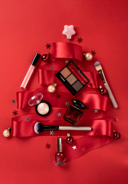 Flat lay composition with makeup products and Christmas decor on red background. Christmas sale of beauty products concept.