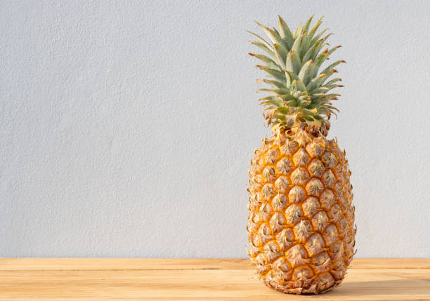istock Ripe pineapple isolated on wooden table 1350352048