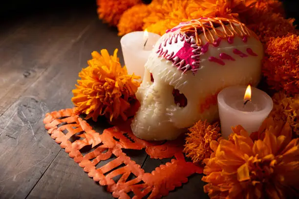 Sugar skull with Candles, Cempasuchil flowers or Marigold and Papel Picado. Decoration traditionally used in altars for the celebration of the day of the dead in Mexico