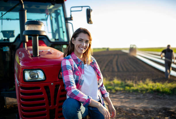 istock Farmer woman leaning on tractor in field 1350361856