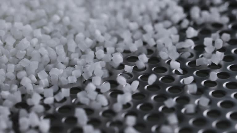 Plastic granules on a vibrating table. Polymer compound production