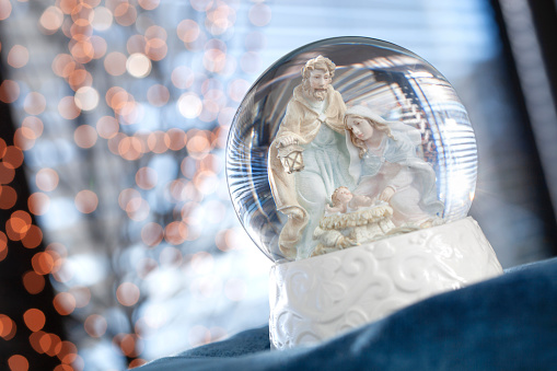 Nativity scene inside the snow globe. Joseph, Mary, and the baby Christ child in a manger.