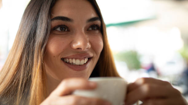 istock young woman drinking coffee and using smart phone 1350368159