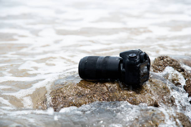 istock DSLR camera on beach wet from water sea wave 1350368981