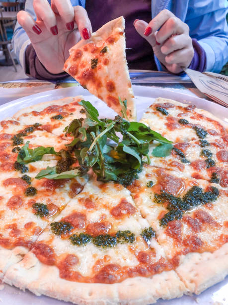 hand taking a slice of four cheese pizza on the plate with selective focus