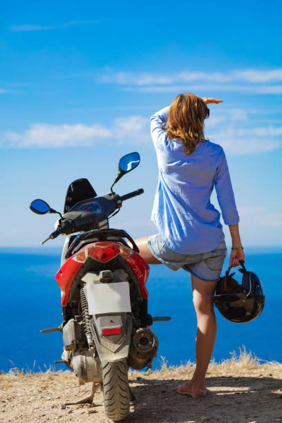 istock Woman with scooter looking at the distant sea horizon. 1350373461