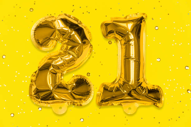 The number of the balloon made of golden foil, the number twenty-one on a yellow background with sequins. The number of the balloon made of golden foil, the number twenty-one on a yellow background with sequins. Birthday greeting card with inscription 21. Numerical digit, Celebration event, template. 21st birthday stock pictures, royalty-free photos & images