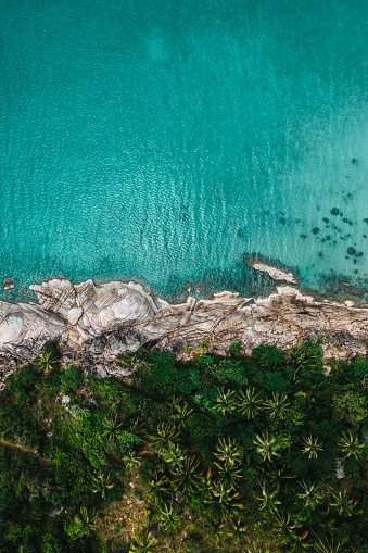 Aerial view of a tropical, rocky seashore.