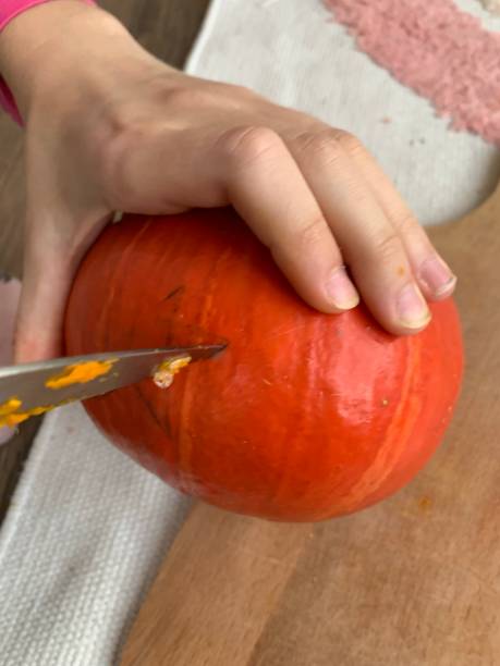istock Child carving a Halloween pumpkin 1350375690