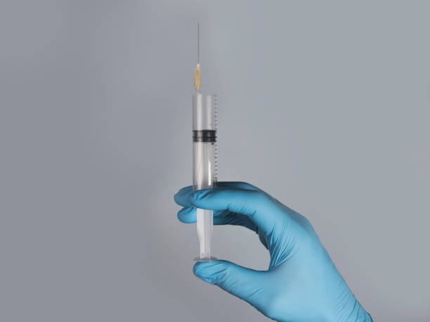 istock Syringe with needle in doctors hands in glove 1350375772