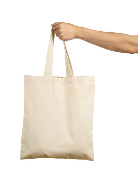 Hand Holding Beige Colour Canvas Tote Bag Isolated on White Background. stock photo