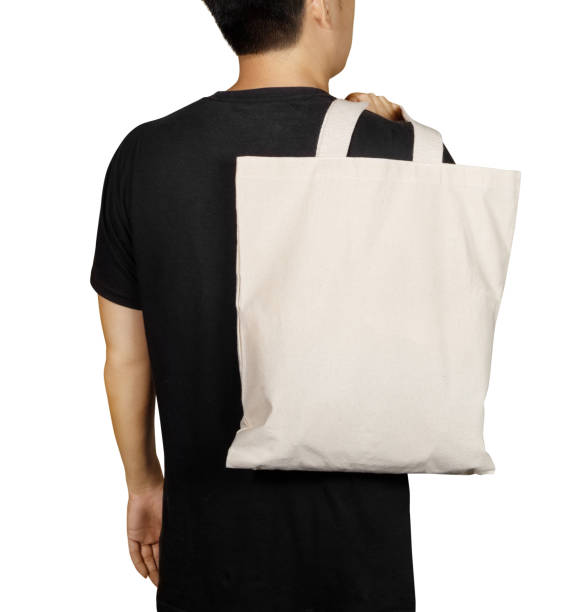 istock Man is holding bag canvas fabric for mockup blank template isolated on white background. 1350380529
