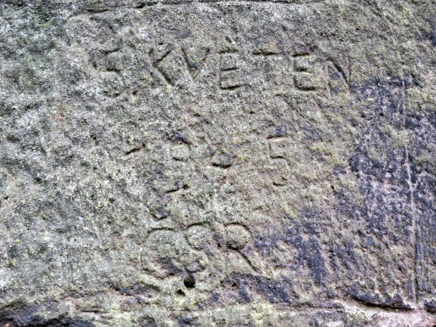 istock Letters engraved by vandals into sandstone rock. 1350383717