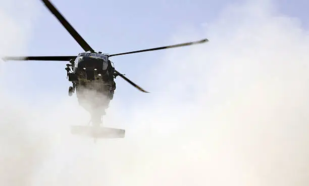 An american blackhawk helicopter coming in for landing and whirling up dust in Mazar-e-sharif, Afghanistan.