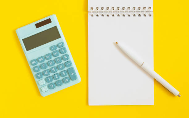 istock Mini calculator, notepad and pen on yellow background. Top view, flat lay. 1350383888