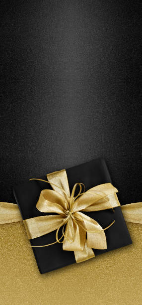 Black Friday gift package wrapped with golden ribbon bow  isolated on black background, template for promotional card with copy space