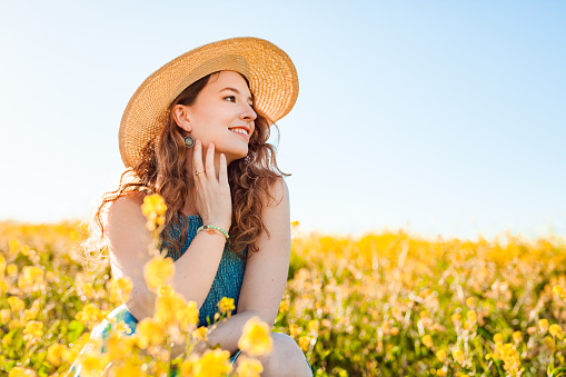 Girl in a yellow flower field looking away