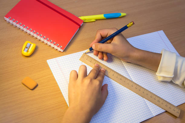 istock A student in a notebook draws a figure with a pencil along a ruler. 1350384972