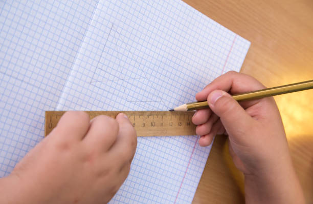 istock The student draws a triangle with a pencil along the ruler. 1350385026