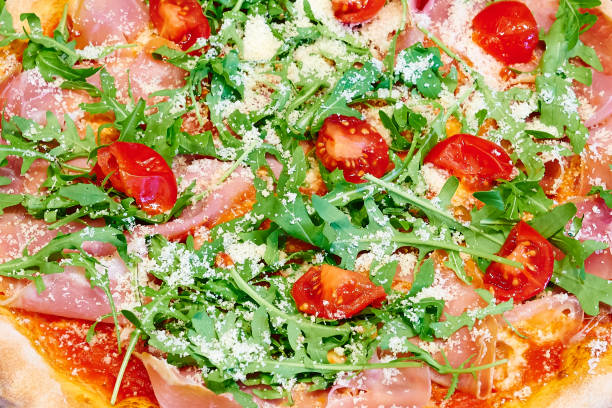 istock Overhead close-up shot of textured Rocket and ham pizza 1350385359