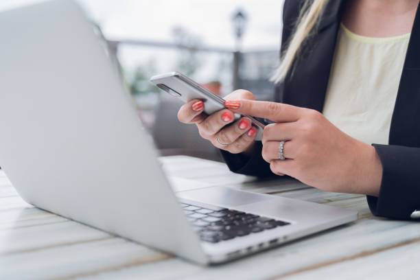 istock Unrecognizable woman browsing smartphone near laptop 1350387442