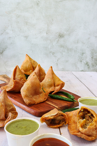 Stock photo showing samosas stuffed with spiced potato, peas and meat. This popular Indian snack is often sold by street food vendors.