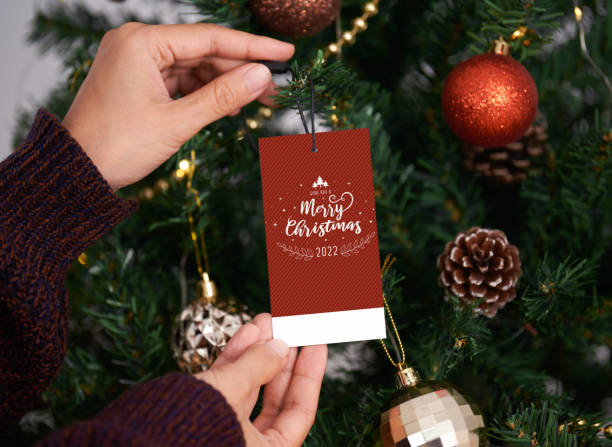 istock Hand holding christmas greeting tags 2022 on christmas tree background. 1350387638