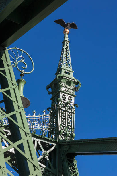 Detail of the ironwork of Szabadság hid (Liberty Bridge), Budapest, Hungary Szabadság híd (Liberty Bridge or Freedom Bridge) in Budapest, Hungary, was built as part of the Millennium World Exhibition at the end of the 19th century. The bridge features art nouveau design, mythological sculptures (including the Turul bird) and the country's coat of arms adorned on its side. art nouveau ironwork stock pictures, royalty-free photos & images