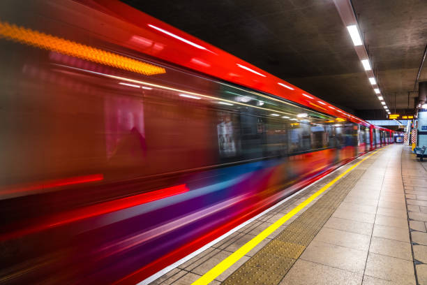 um trem subterrâneo em movimento - canary wharf railway station - fotografias e filmes do acervo