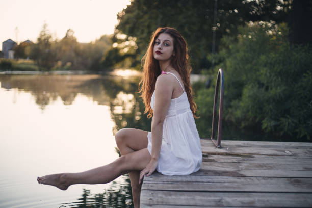 istock Woman sitting on pier 1350397815