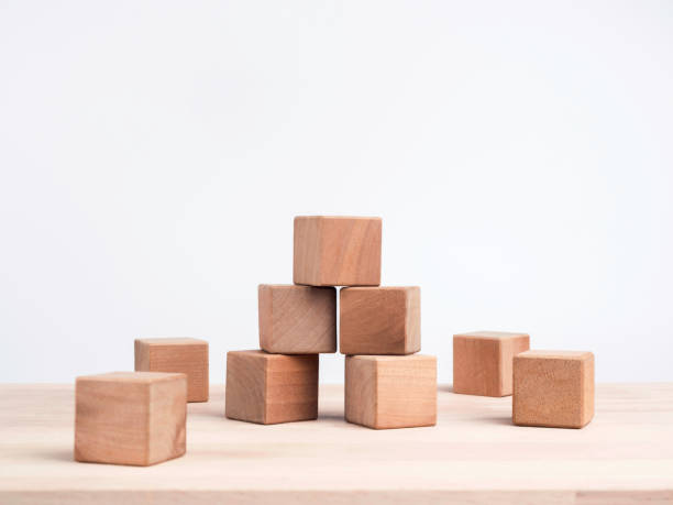 istock Empty wooden cube blocks on the table on white background with copy space. Many wood bricks building tower construction. Mockup composition for design.