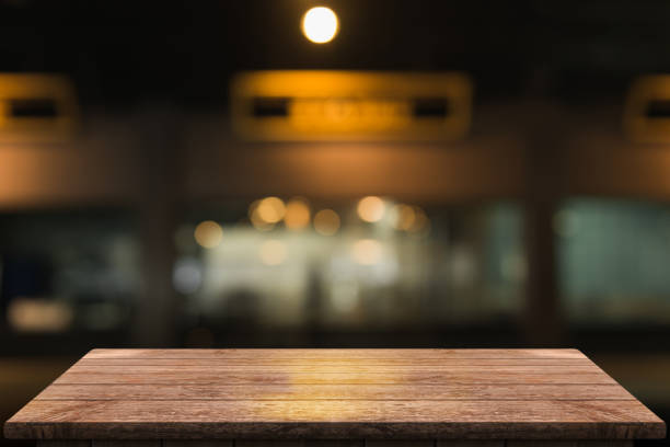 istock Empty wooden table top with lights bokeh on blur restaurant background 1350411938