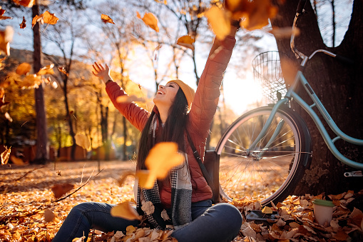 Woman throwing autumn leaves in the air