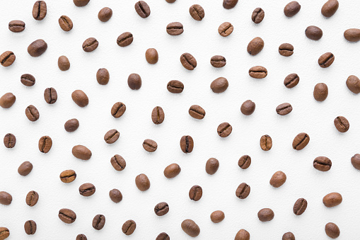 Coffee beans building a grid pattern on white background.