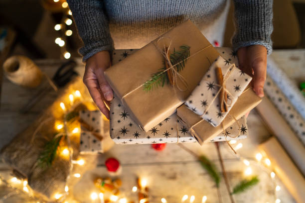 istock Two hands lifting wrapped Christmas gifts 1350415270