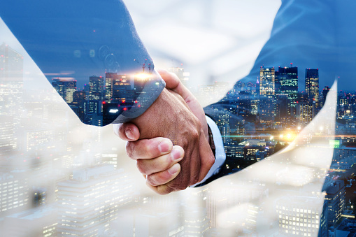Partnership. multi exposure of investor businessman handshake with partner for successful meeting with night city background, digital technology, investment, negotiation, partnership, teamwork concept